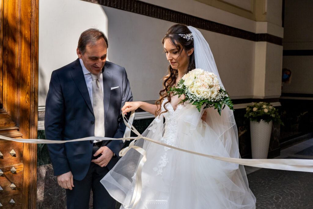 Taglio del nastro la sposa esce di casa con il papà e come da tradizione taglia il nastro