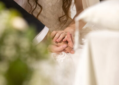 Sposi si tengono per mano durante la cerimonia del loro matrimonio